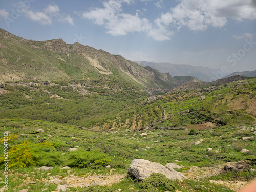 A green hillside with orchard terraces overlooks a mountain village nestled within layered spring valley mountain ranges.
📍 Hawraman Takht, Kurdistan, Iran 