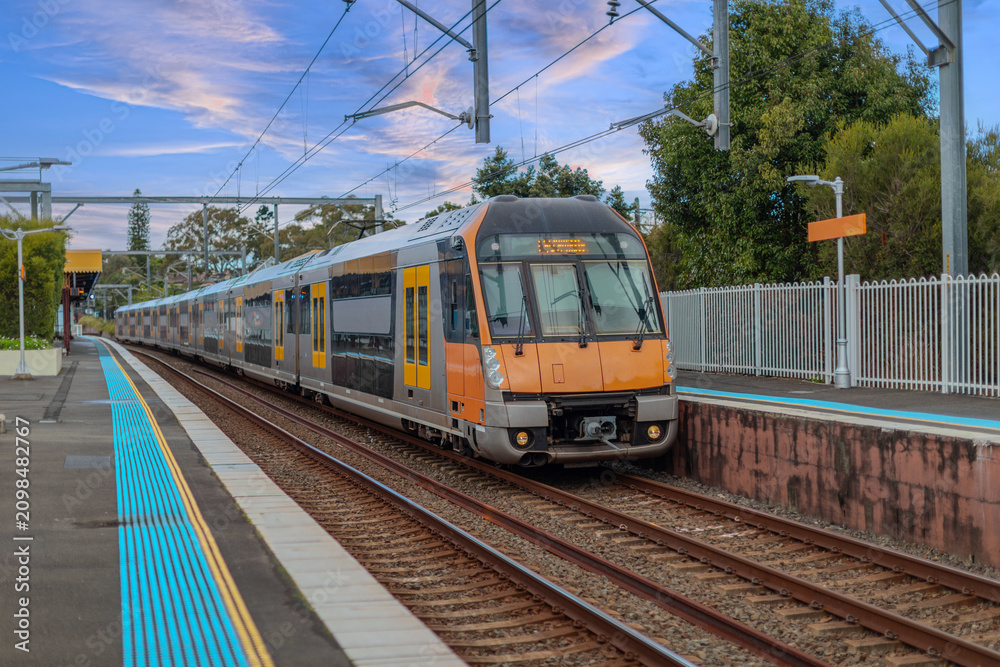 Obraz premium Passenger Train going through Lewisham Train Station at Sunset a suburban Sydney train Station in Sydney NSW Australia