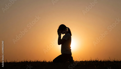 Christian woman kneeling in devotion during golden hour