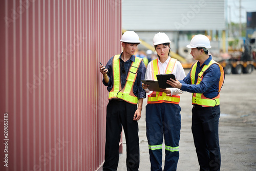 Workers walking and inspecting cargo containers