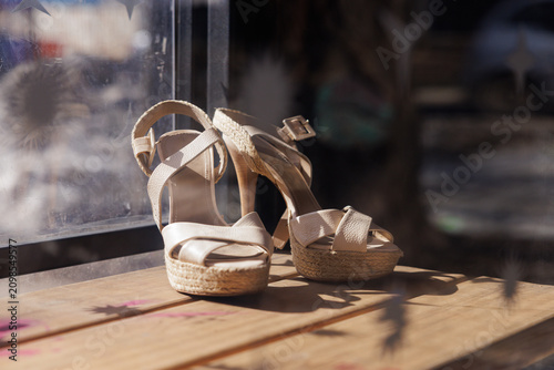 Slika na platnu Elegant summer sandals basking in warm sunlight by a cozy window display
