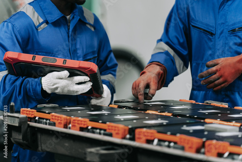 Technicians Diagnosing and Disassembling Electric Vehicle Battery