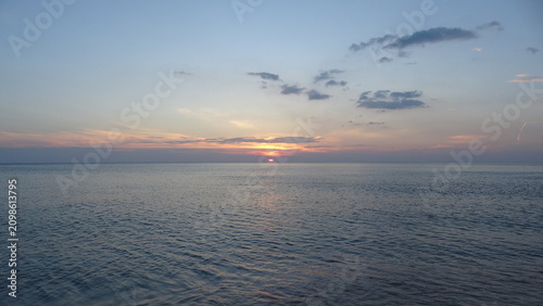 Photos The first ray of sun peeking over the horizon at sea