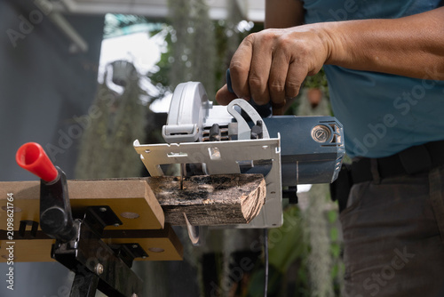 Fotografie Circular saw straight crosscut wood on sawhorses. Low angle view.