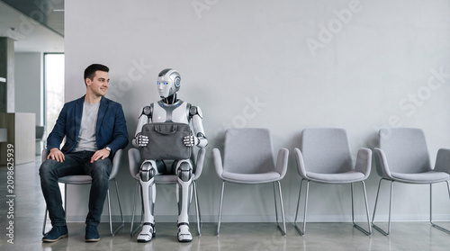 Man and humanoid robot waiting in chairs for job interview
