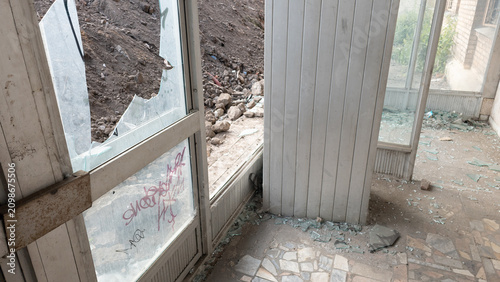Tableau sur toile Abandoned interior of an old building with broken windows, damaged surfaces and