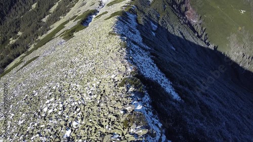 Scenic aerial view of alpine ridge with snow patches and rocks