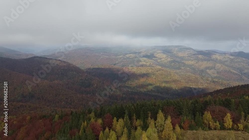 Scenic aerial of autumn highlands with low clouds and forest