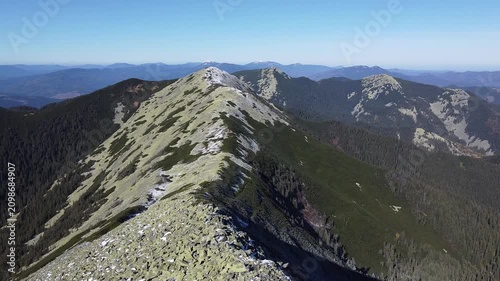 Aerial drone flight over rocky mountain ridge with first snow