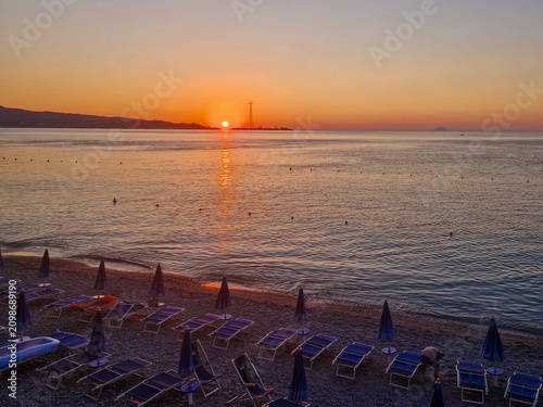 Bild auf Leinwand The sun sets on the Sicilian coast as seen from Scilla, on the opposite Calabrian coast
