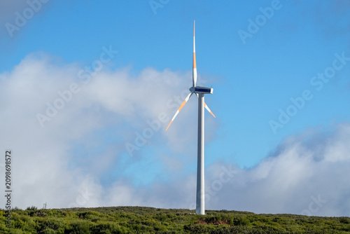 The wheels of a wind turbine are turning on the plateau of Madeira.