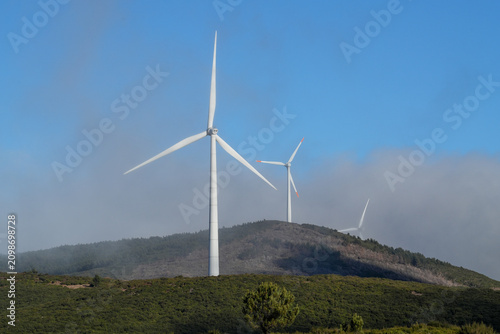 The wheels of a wind turbine are turning on the plateau of Madeira.