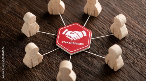 Wooden business figures connected to central stakeholder on dark wooden surface