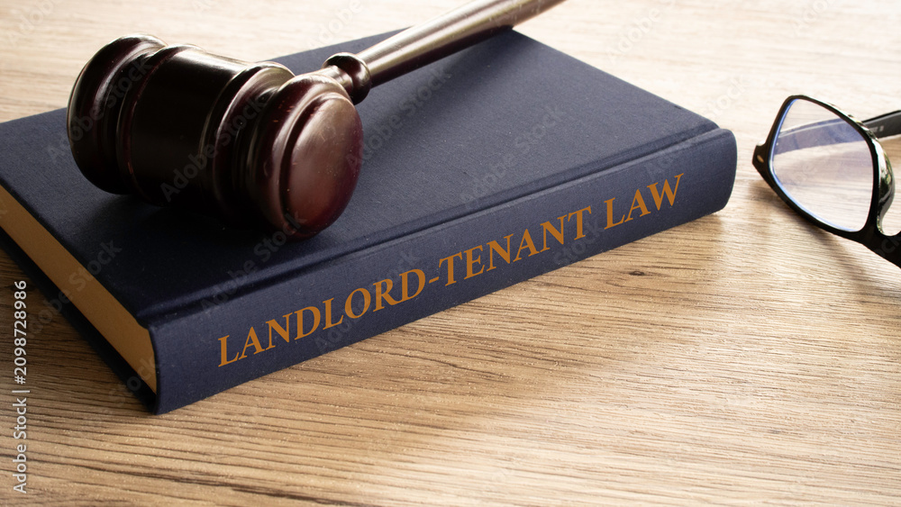 Fototapeta premium Landlord Tenant Law book with gavel and eyeglasses on wooden table