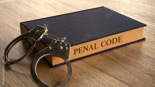 Obraz na plátně Penal Code Law Book with Handcuffs on Wooden Desk