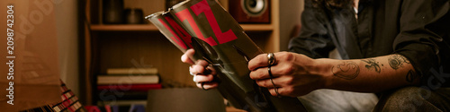Quadro su tela Header of young adult musician holding vinyl record at home, reviewing music inspiration and creative identity