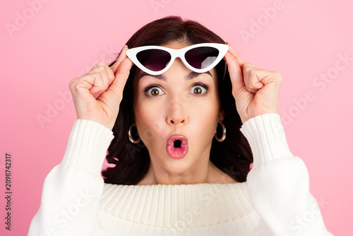 Fotografija Surprised young woman lifting white cat-eye sunglasses with playful expression o