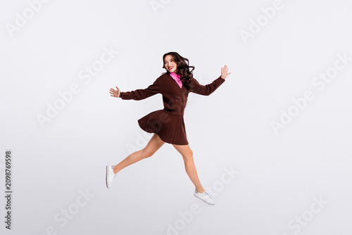 Принти на полотні Charming young businesswoman wearing trendy outfit jumping on white background s