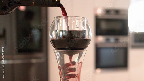 Foto Red Wine Pouring Through Glass Spiral Aerator Into Decanter
