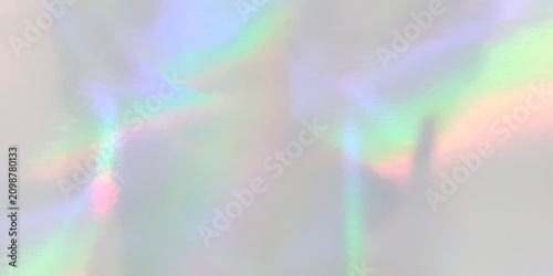 Holographic silver texture background with vibrant rainbow neon light reflections. Iridescent metallic foil backdrop ideal for trendy futuristic and colorful modern graphic design
