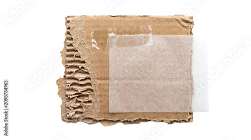 Quadro su tela Corrugated cardboard scrap with translucent vellum paper and clear tape on a tra