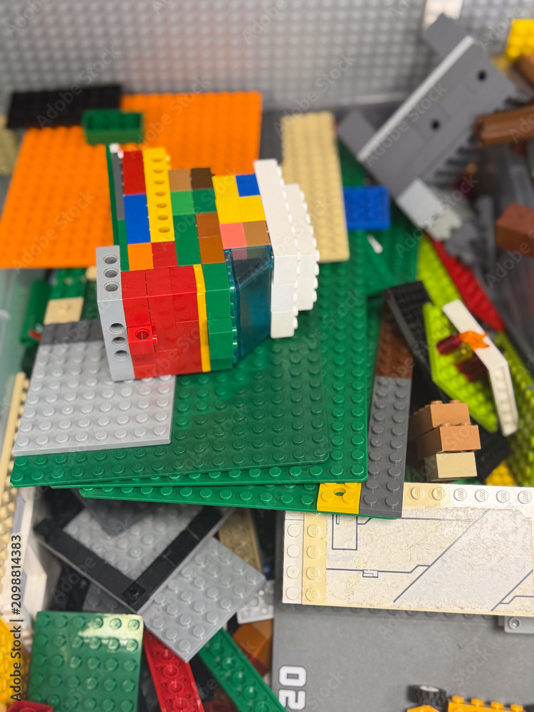 Fototapeta premium Colorful lego bricks and plates piled together in a close-up view, showing a mix of shapes, textures, and bright colors for creative play and building.