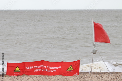 Red flag, signifying 'do not swim' , on beach at Clacton on Sea, Essex, UK