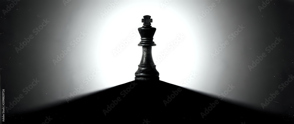 Obraz premium Queen chess piece silhouetted against bright backlit glow, symbolizing leadership, strategy, and power for business and game concepts.