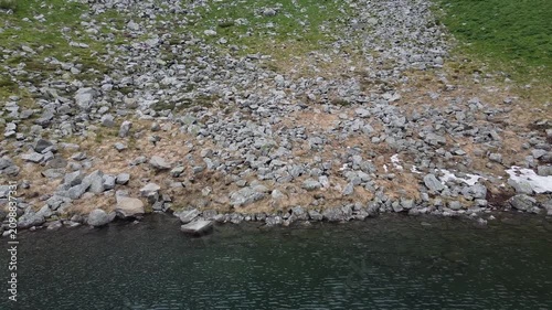 Scenic aerial panorama of alpine lake in mountain cirque