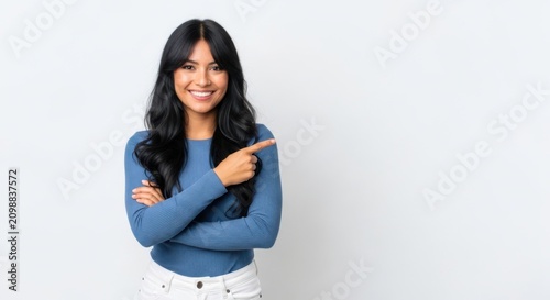 Young woman smiling and pointing at camera with arms crossed