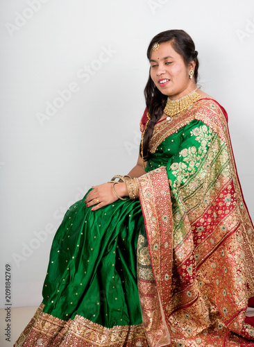 Fotografie Cheerful indian young girl posing in traditional Indian saree on white background