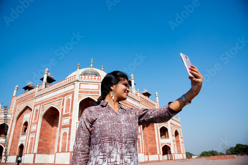 Canvas Print Young girl taking Photos in front of Humayun's Tomb, Delhi, India