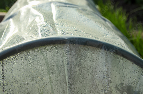Obraz na plátně Greenhouse effect concept with water drops on plastic film cover