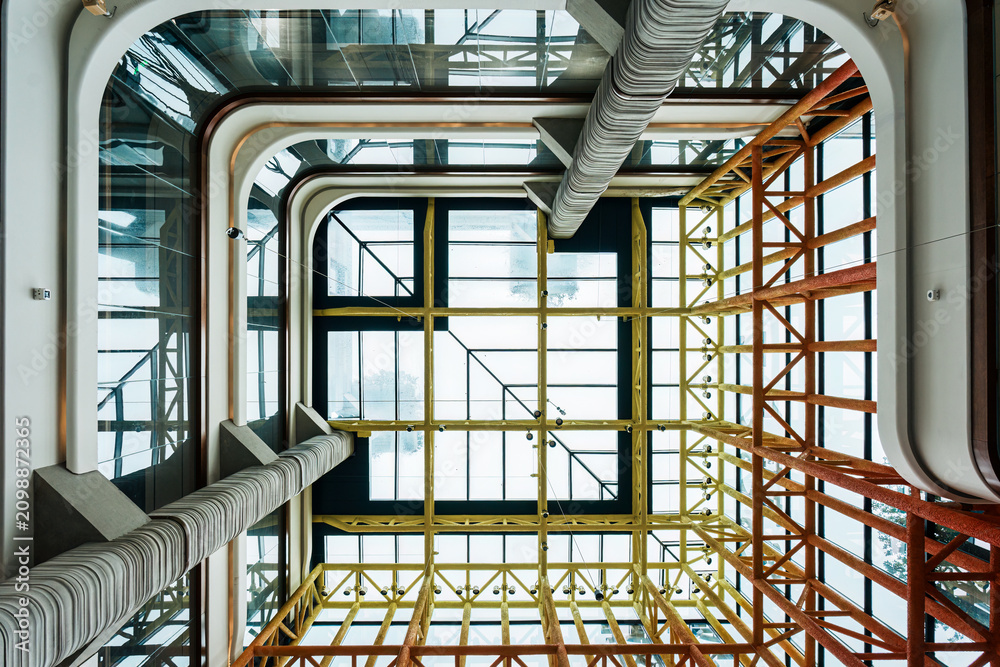 Obraz premium Modern Atrium Interior Looking Up Through Multiple Glass Floors with Industrial Skylight Design