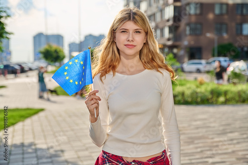 Smiling young woman holding flag of European Union