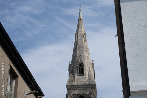 Fotografía Church spire seen between rooftops on sunny day