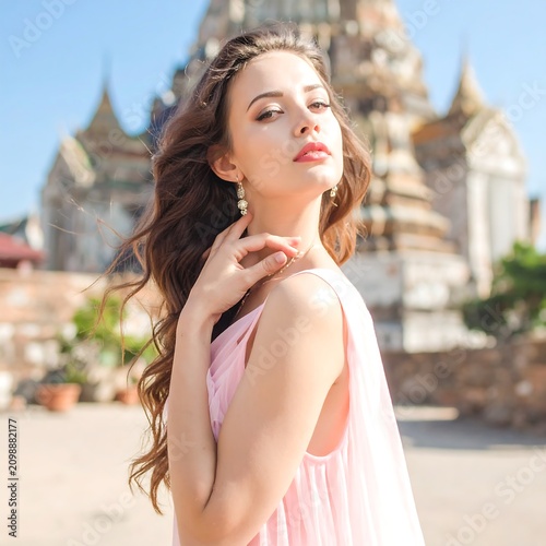 Woman in pink dress near ancient temple