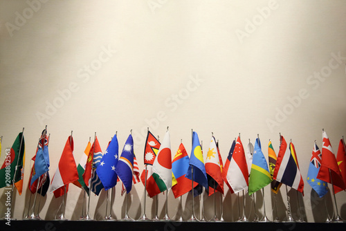 Photos 横に並んだ世界各国の卓上旗、カラフルな卓上万国旗、国際交流やグローバル会議をイメージした世界の国旗