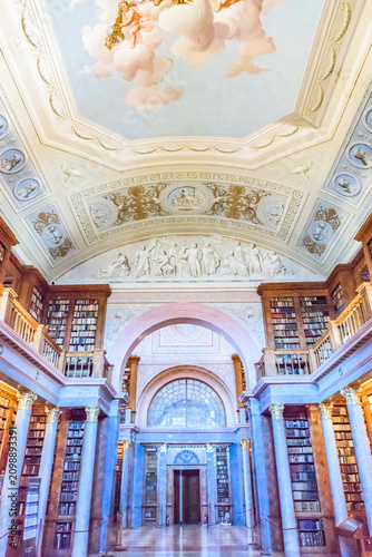 The magnificent neoclassical interior of the historic Pannonhalma Archabbey Library with ancient books and ceiling paintings, a UNESCO World Heritage Site.
