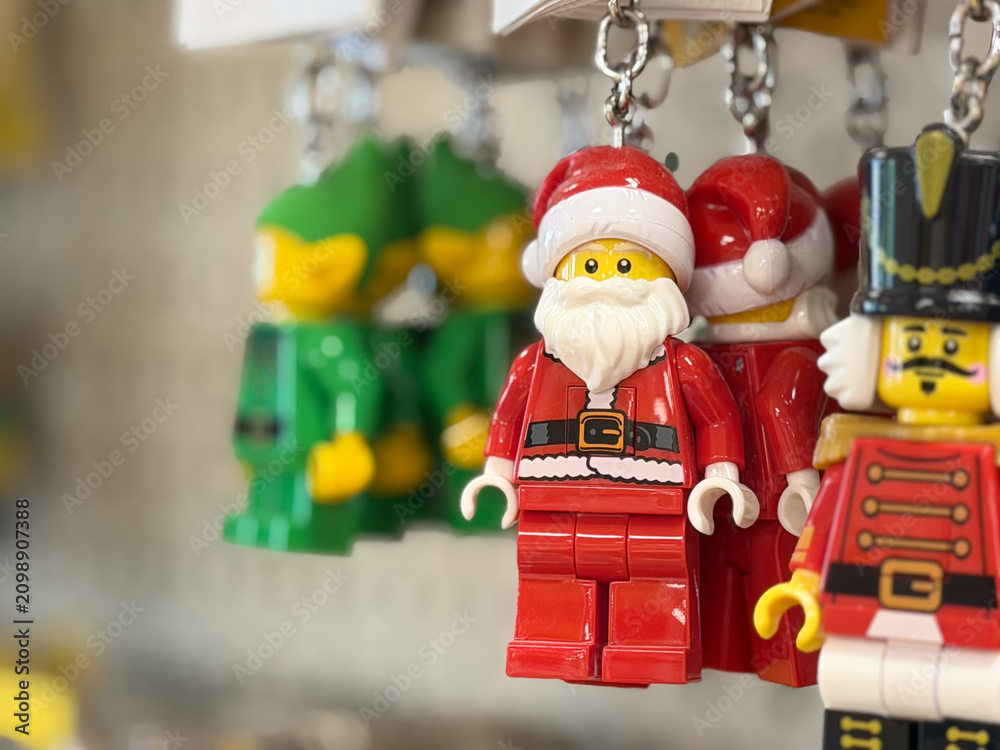 Fototapeta premium Close-up of hanging toy Santa and nutcracker keychains with a blurred background, showing bright christmas colors and a festive holiday mood.