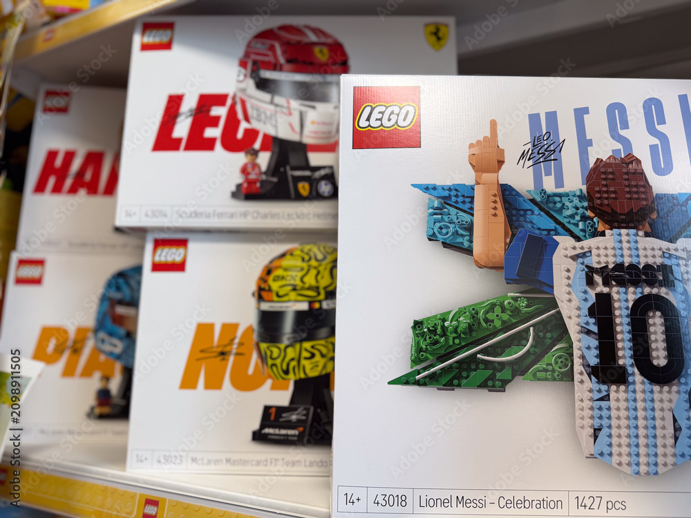 Fototapeta premium Lego toy boxes with sports sets and lionel messi celebration on a retail shelf in a store, showing colorful packaged building blocks and collectibles.