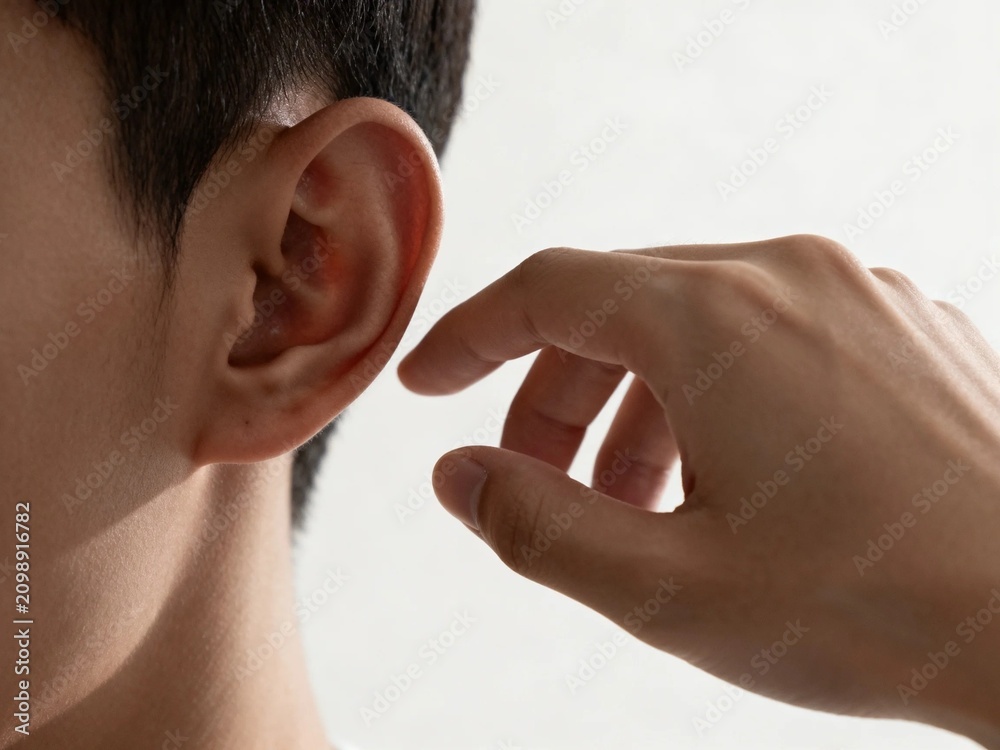 Fototapeta premium Close-up of Hand Touching Ear Against Soft Light