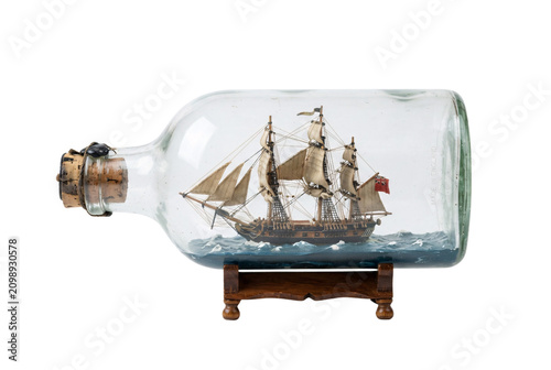 Vintage model ship inside a glass bottle, detailed rigging, resting on a small wooden stand, nautical decor item.