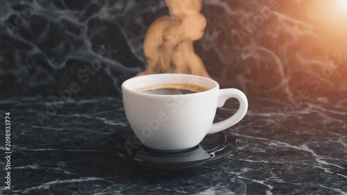 A steaming cup of coffee on a dark marble surface