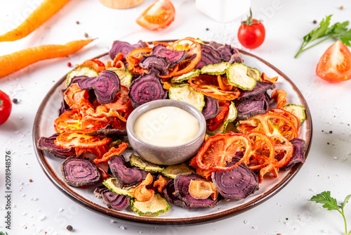 Healthy alternative for traditional potato chips, snack air fried vegetables chips, raw organic dehydrated veggie chips, beets, carrots, zucchini, kale, tomatoes, with white sauce dip