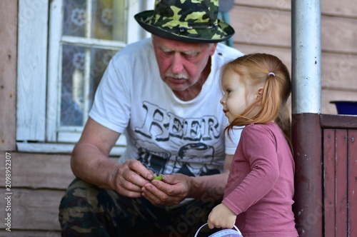 Canvastavla Heartwarming outdoor portrait of a grandfather showing something to his curious granddaughter