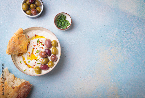 Labneh yogurt dip with olives and pita bread Middle Eastern meze top view copy space