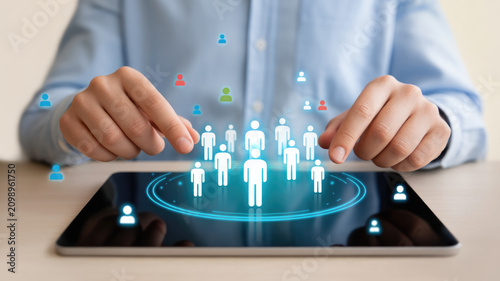 Digital human resources management interface with glowing user icons displayed on a modern tablet screen