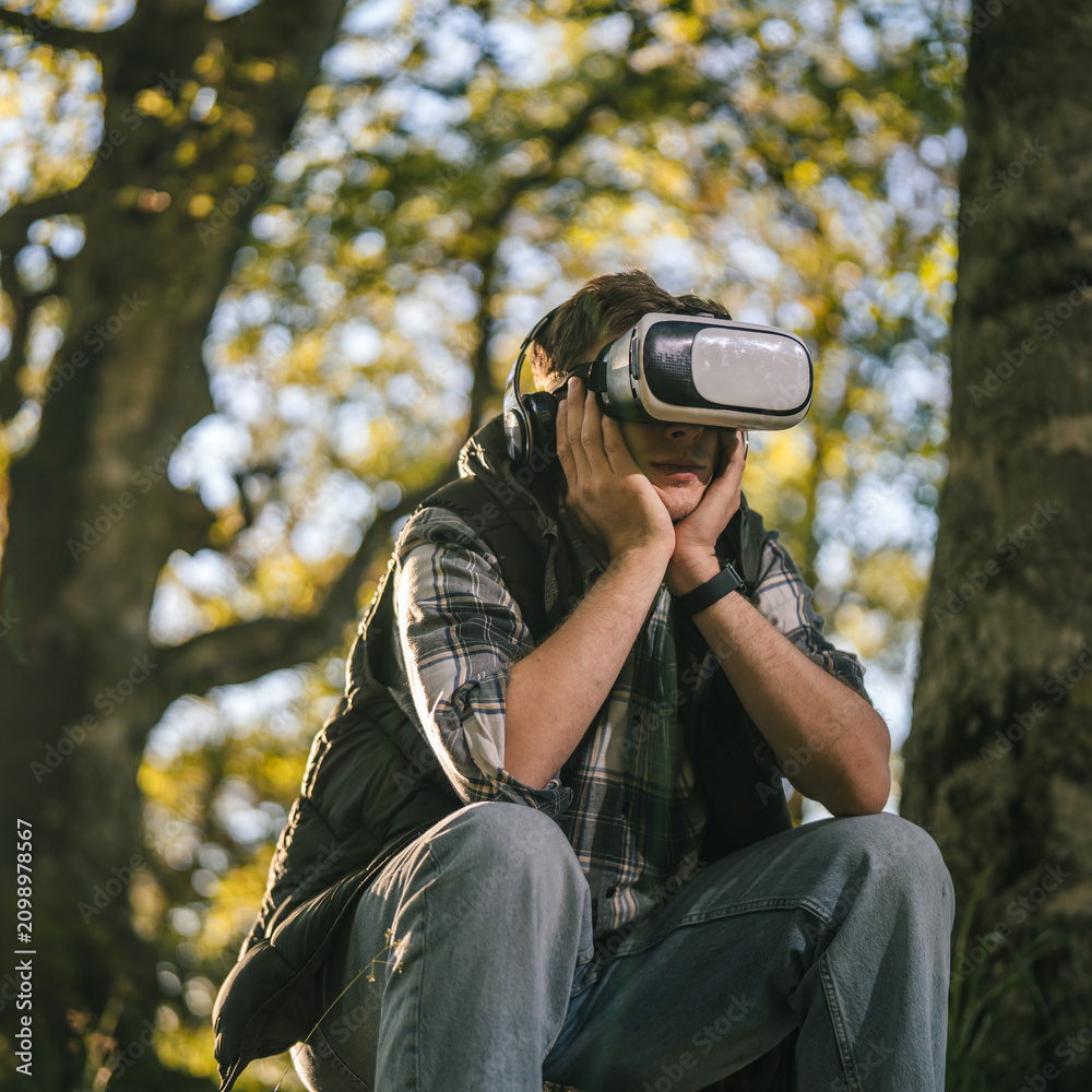 Obraz premium Man experiencing virtual reality outdoors in technology escape