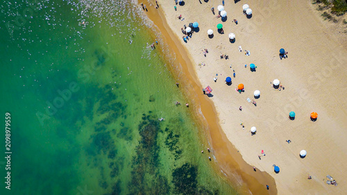 Εκτύπωση καμβά Top-down drone view of beach umbrellas, sunbathers and crystal-clear water along a sandy beach in Punta del Este, Uruguay, on a sunny summer day